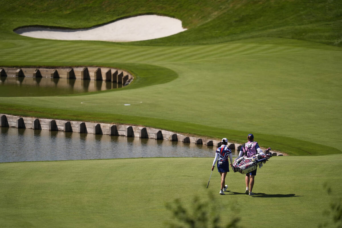Rose Zhang, of the United States, and her caddie walk to the 1st green during the final round o ...
