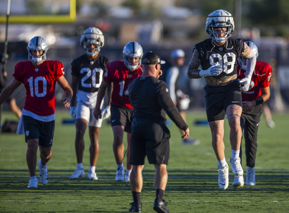 Raiders defensive end Maxx Crosby (98) catches some air during warm ups at practice in the Inte ...