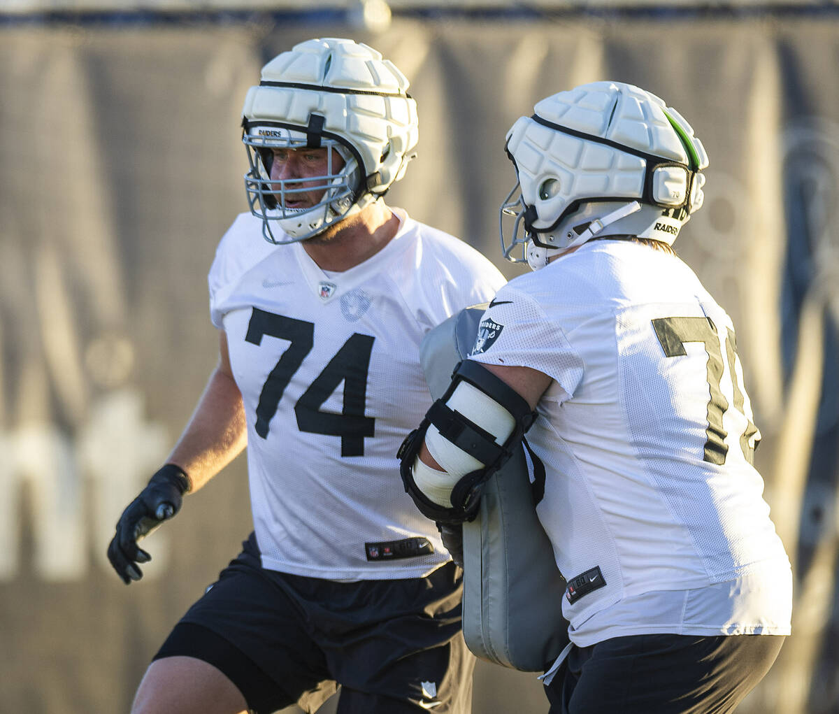 Raiders offensive tackle Kolton Miller (74) runs a drill with guard Jackson Powers-Johnson (70) ...