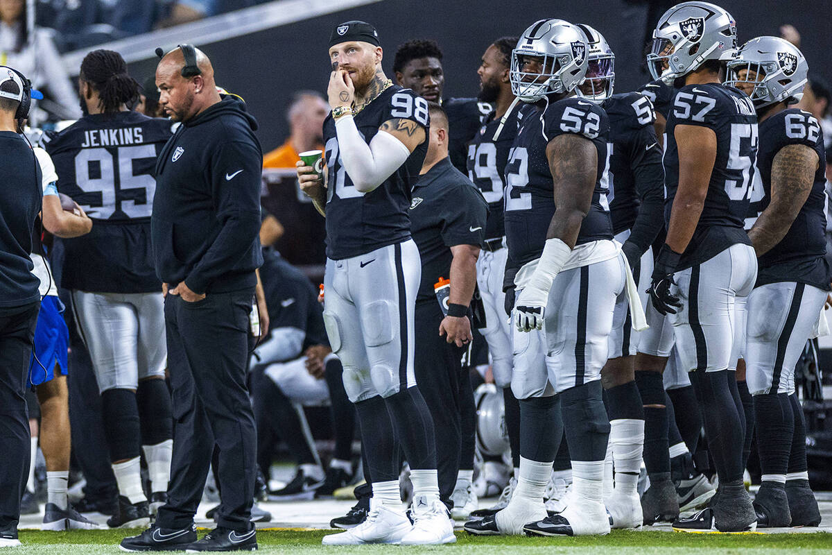 Raiders head coach Antonio Pierce appears dismayed as defensive end Maxx Crosby (98) chews his ...