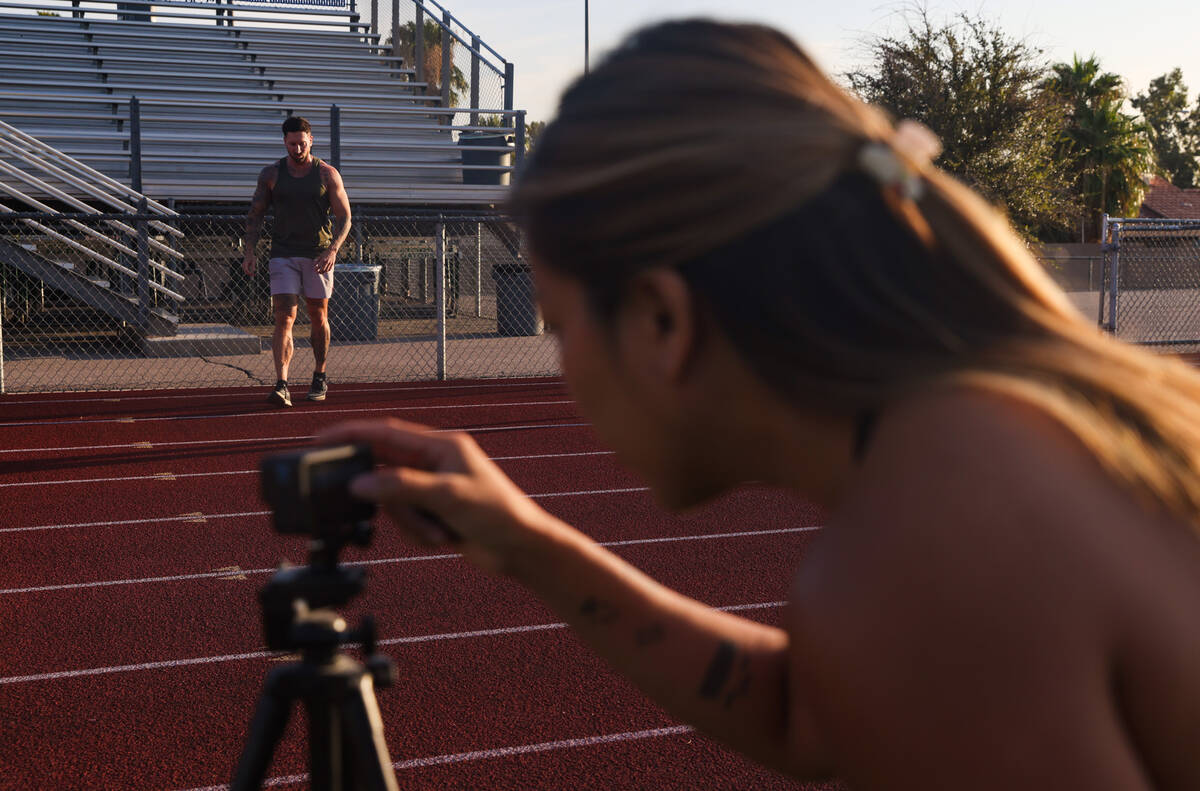 Troy Adashun, a local fitness influencer, warms up before sprinting as his wife Kathy Adashun s ...