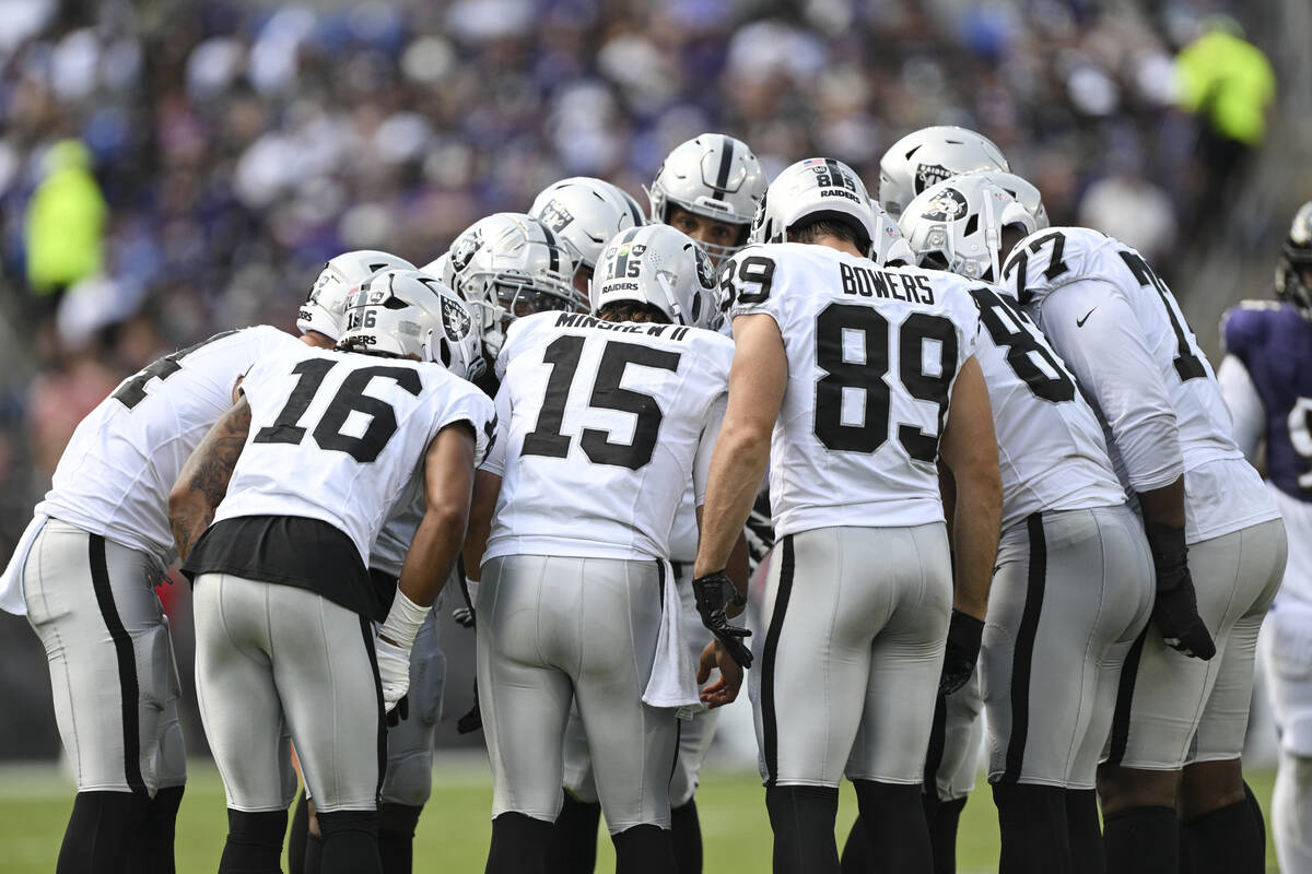 The Las Vegas Raiders offense huddles during the first half of an NFL football game against the ...