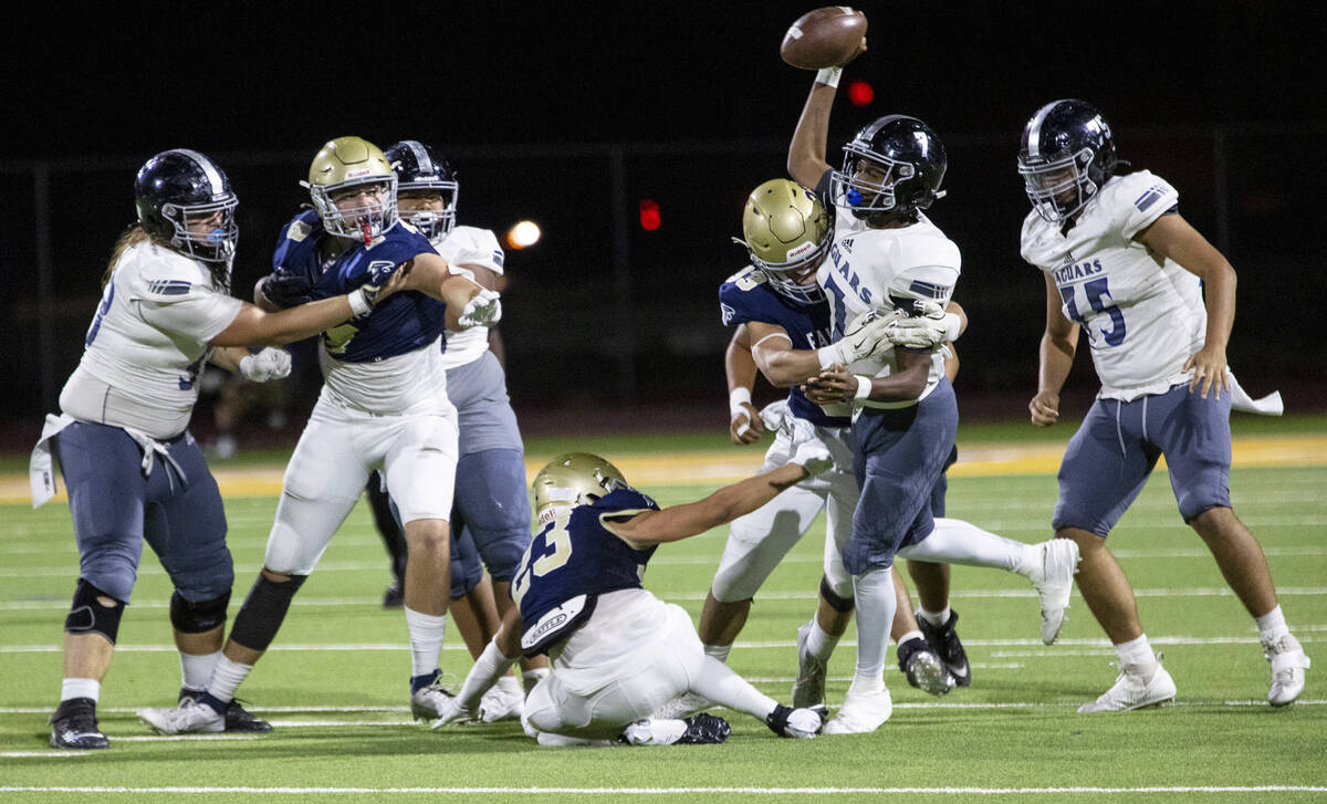 Desert Pines quarterback Zeyshawn Martin (7) is hit while throwing the ball during the high sch ...