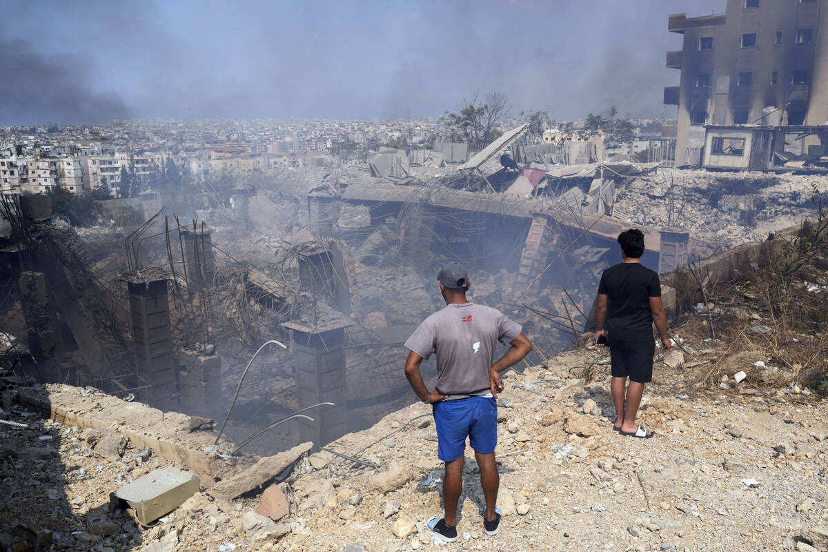 People check a damaged building at the site of an Israeli airstrike in Choueifat, south east of ...