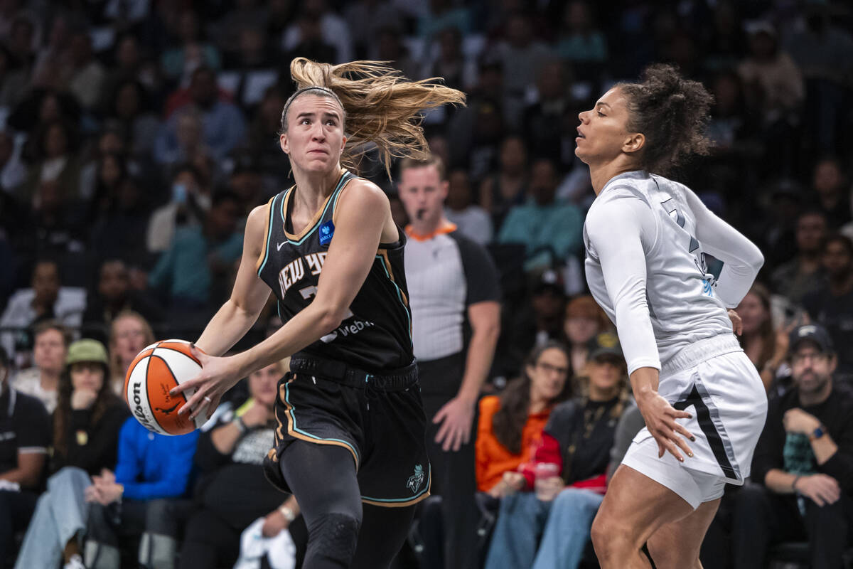New York Liberty forward Brenna Stewart, left, is defended by Las Vegas Aces forward Alysha Cla ...