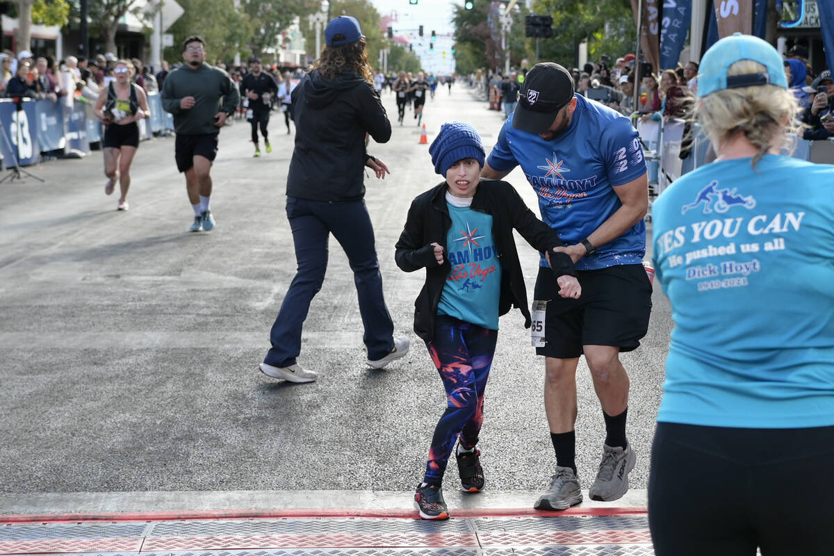 Team Hoyt rider athlete Taylor Little crosses the finish line with Brian Weber during the Las V ...
