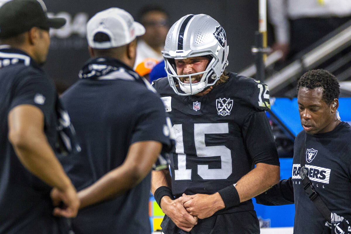 Raiders quarterback Gardner Minshew (15) is escorted off the field after a sack with a collarbo ...