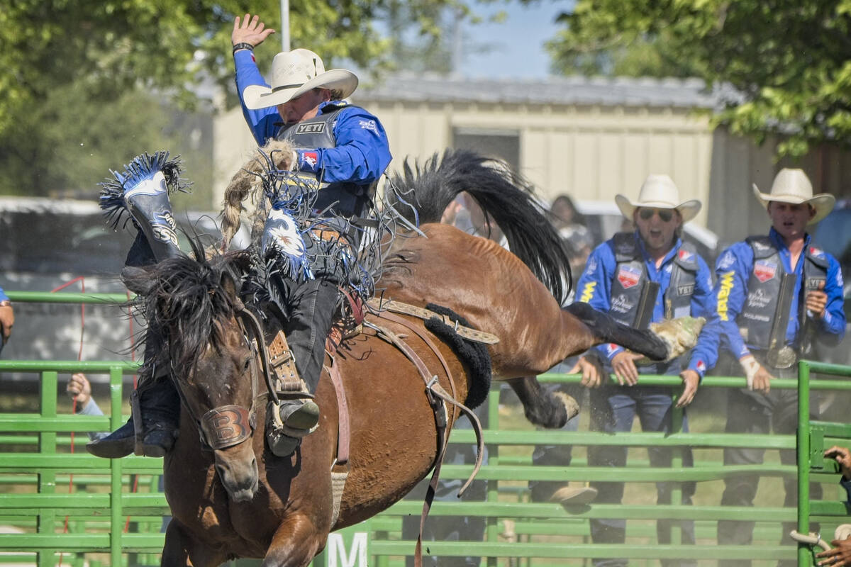 Statler Wright competes in saddle bronc riding while his brothers Ryder, right, and Rusty cheer ...