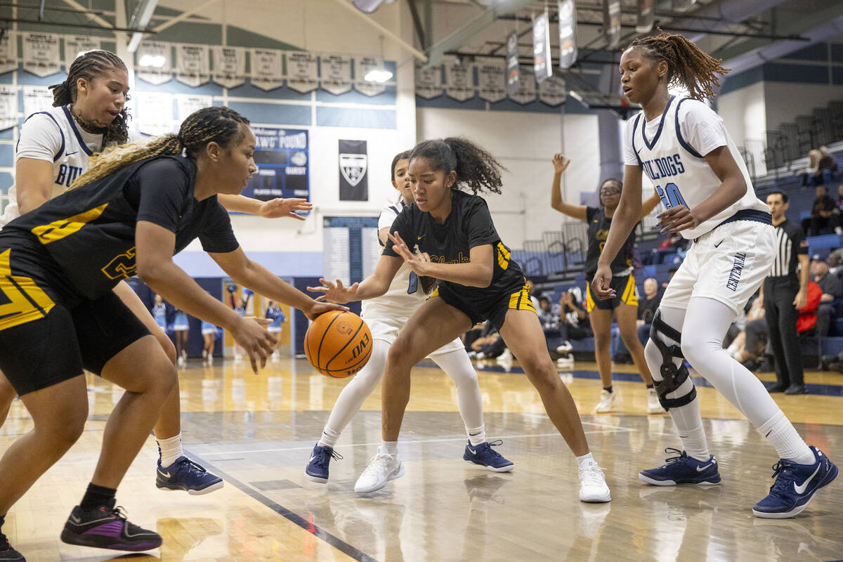 Clark and Centennial players look to grab the ball during the high school girls basketball game ...