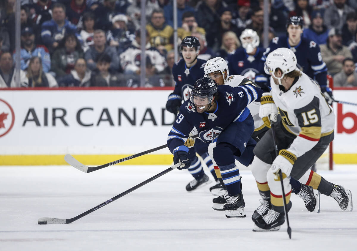 Winnipeg Jets' Alex Iafallo (9) chases down a loose puck as Vegas Golden Knights' Noah Hanifin ...