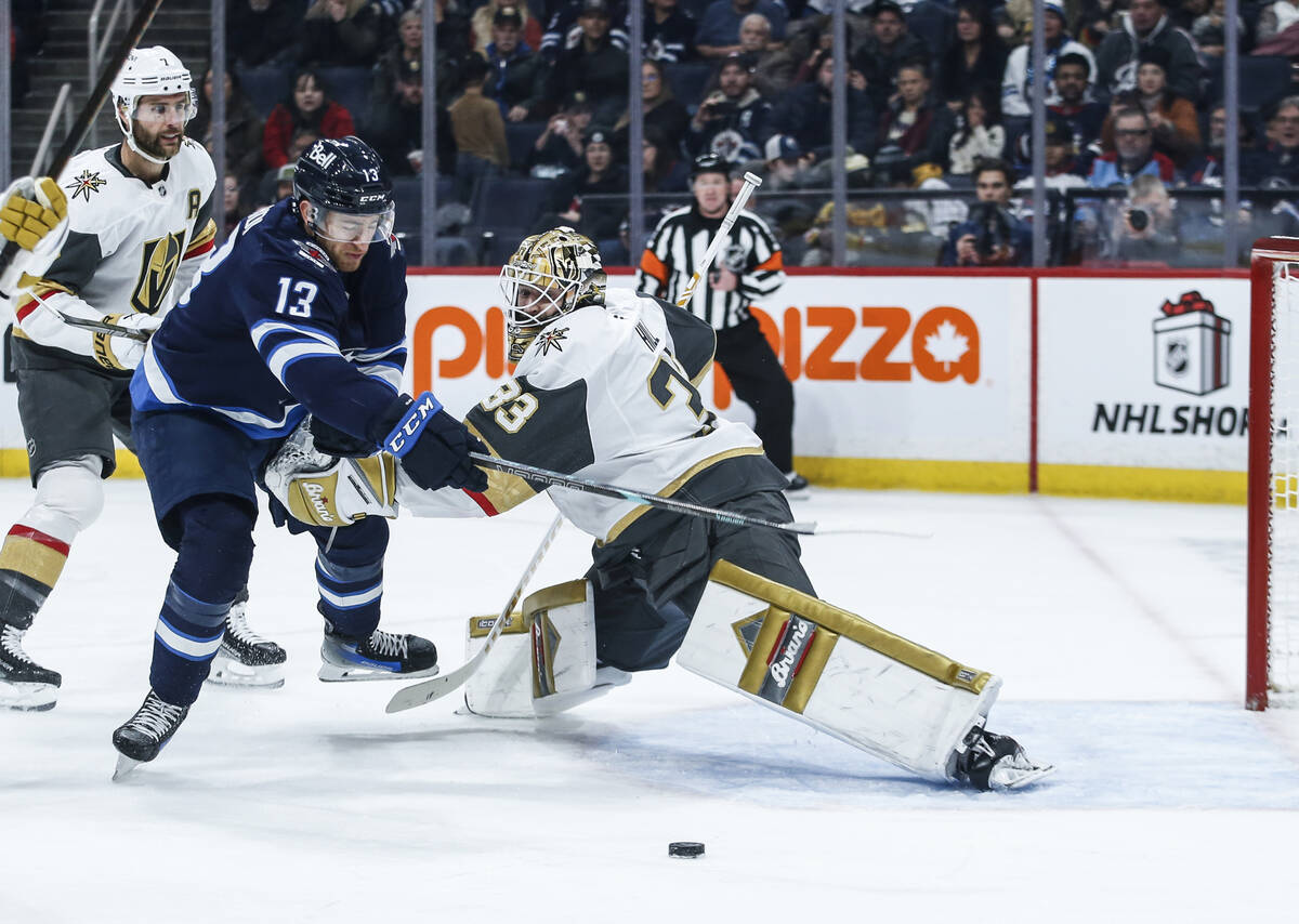 Winnipeg Jets' Gabriel Vilardi (13) tries to break around Vegas Golden Knights goaltender Adin ...