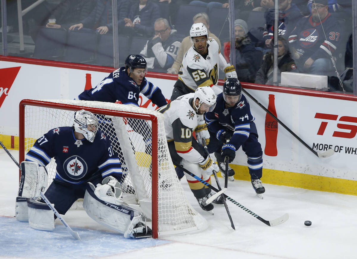 Winnipeg Jets' Josh Morrissey (44) defends against Vegas Golden Knights' Nicolas Roy (10) who a ...