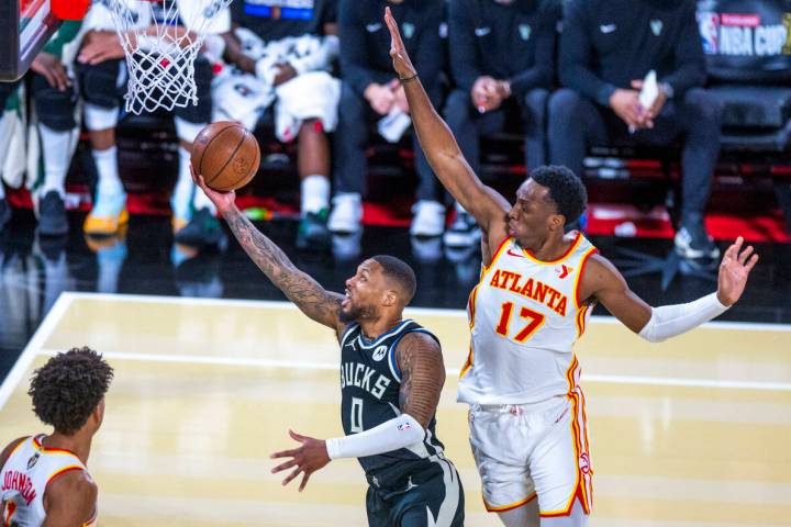 Milwaukee Bucks guard Damian Lillard (0) gets underneath Atlanta Hawks forward Onyeka Okongwu ( ...
