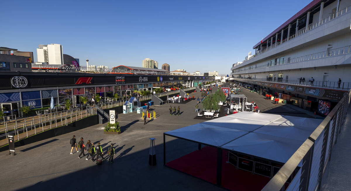 Crew members walk along the interior of the Formula One pit building during a tour before the s ...