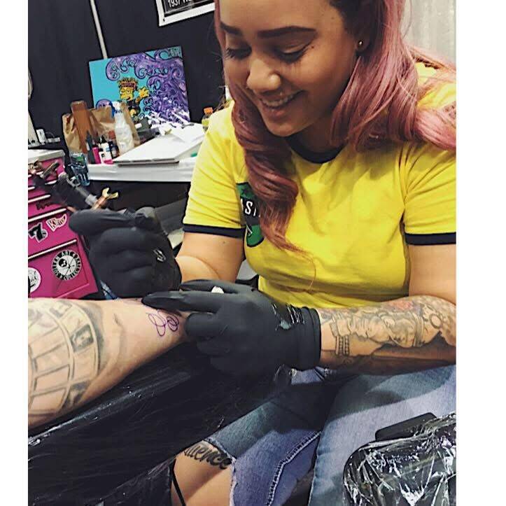 Renise "NeNe" Wolfe gives someone a tattoo. (Courtesy)