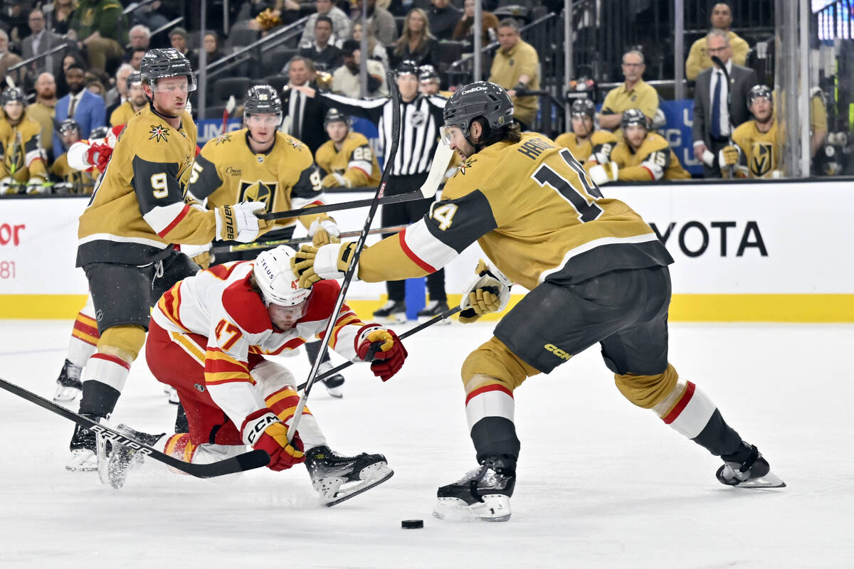 Calgary Flames center Connor Zary and Vegas Golden Knights defenseman Nicolas Hague vie for the ...