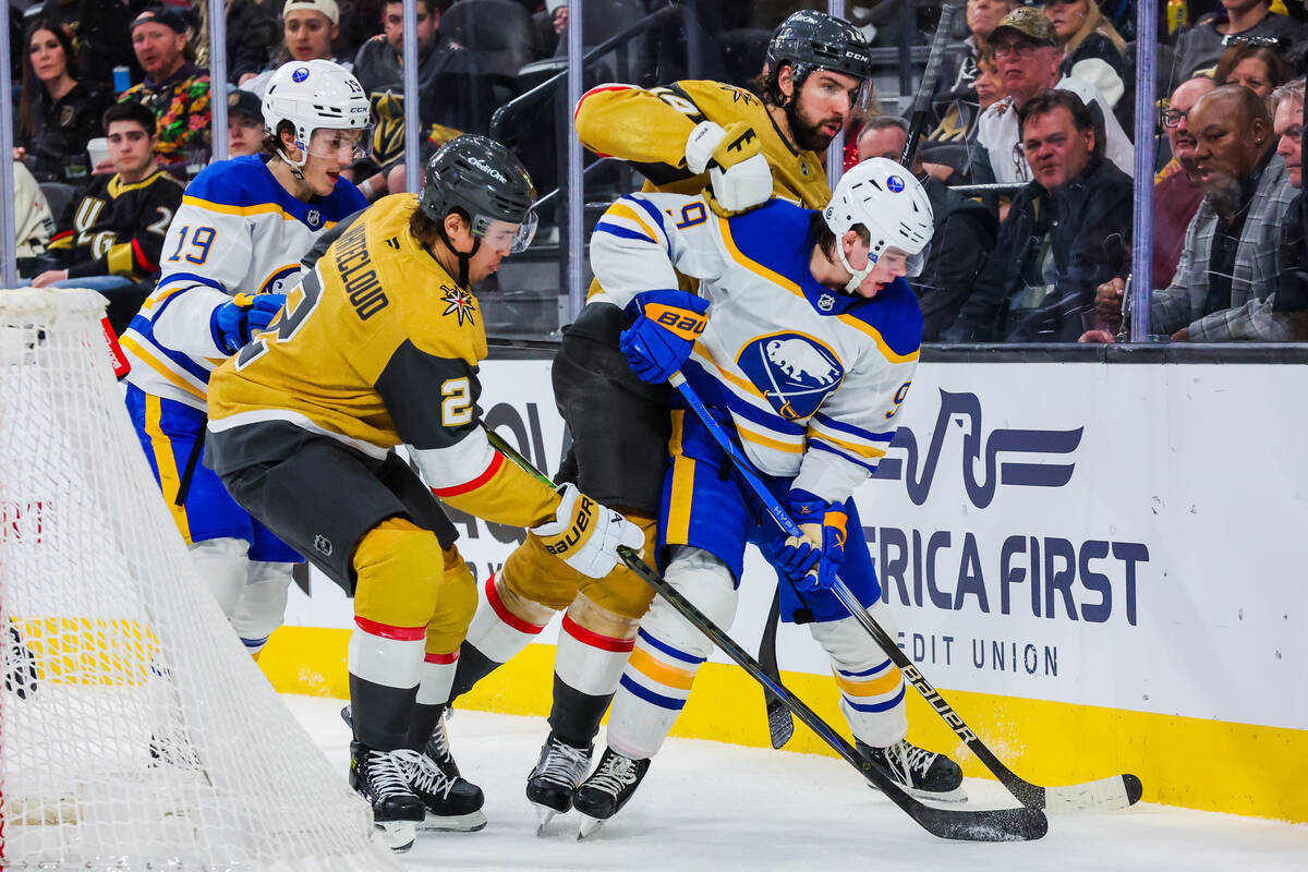 Buffalo Sabres left wing Zach Benson (9) tries to push the puck away from Golden Knights defens ...