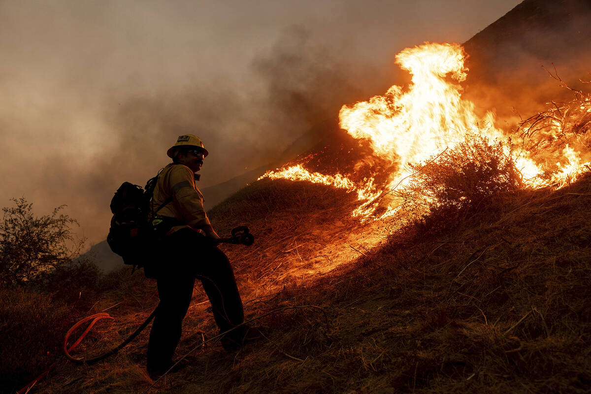 A firefighter monitors the advance of the Kenneth Fire in the West Hills section of Los Angeles ...