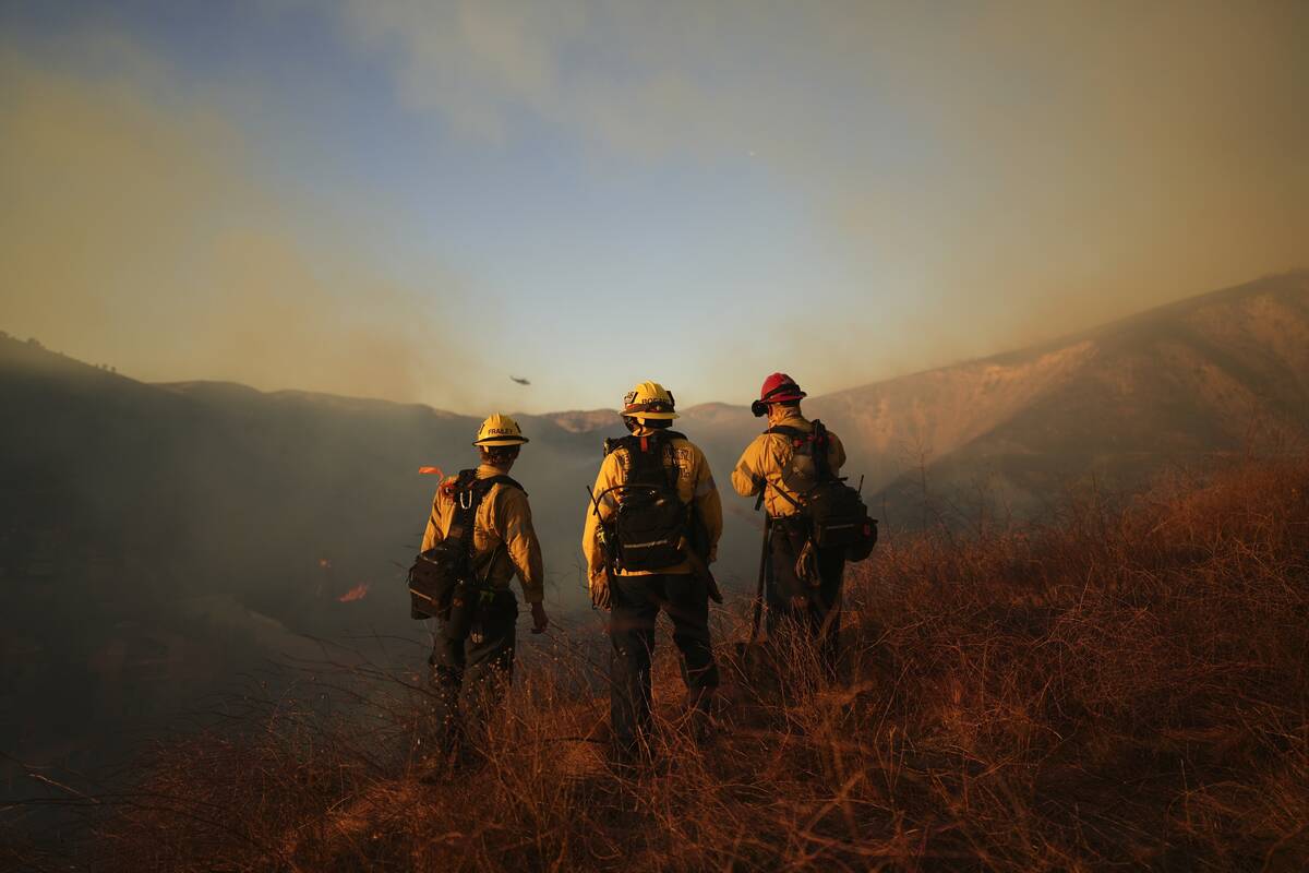 Firefighters look out over the Kenneth Fire, Thursday, Jan. 9, 2025, in the West Hills section ...