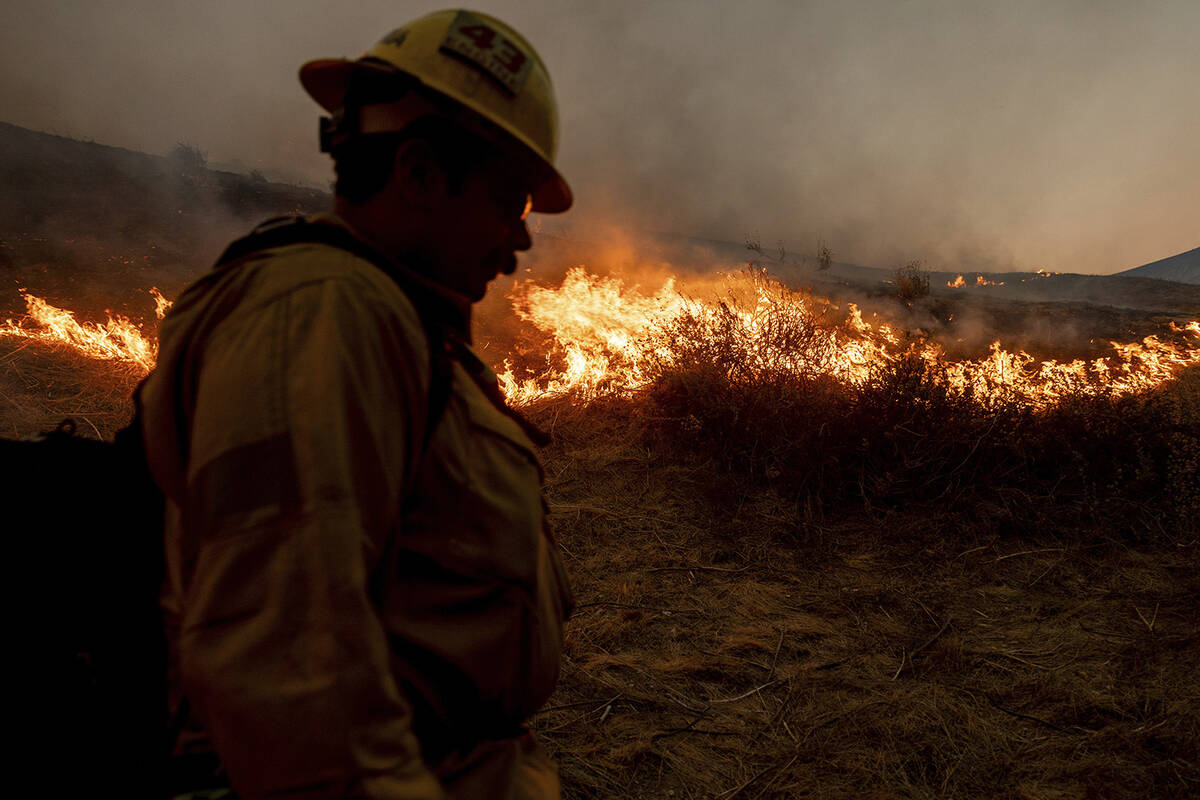 A firefighter monitors the advance of the Kenneth Fire in the West Hills section of Los Angeles ...