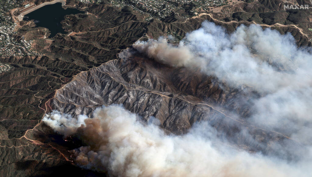 In this photo provide by Maxar Technologies, the Palisades Fire burns south of the Encino Reser ...