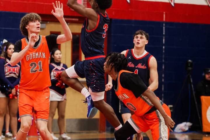 Coronado’s Jalen St. Clair leaps up for a basket as Bishop Gorman center Chris Boudreau ...