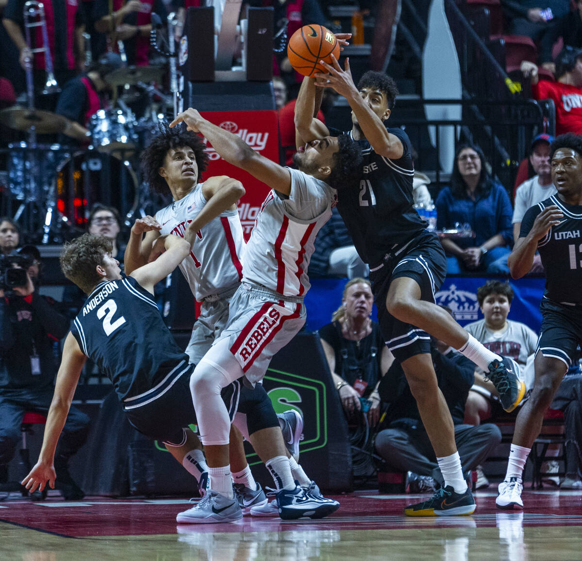 UNLV forward Jeremiah Cherry (45) is run int6o as Utah State Aggies center Aubin Gateretse (21) ...