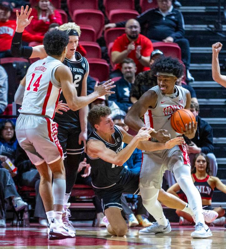 UNLV forward Jacob Bannarbie (12) rips the ball away from Utah State Aggies guard Mason Falslev ...