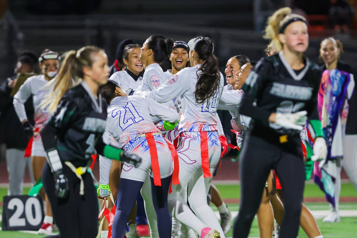 Liberty teammates celebrate an interception during a high school girls flag football game betwe ...