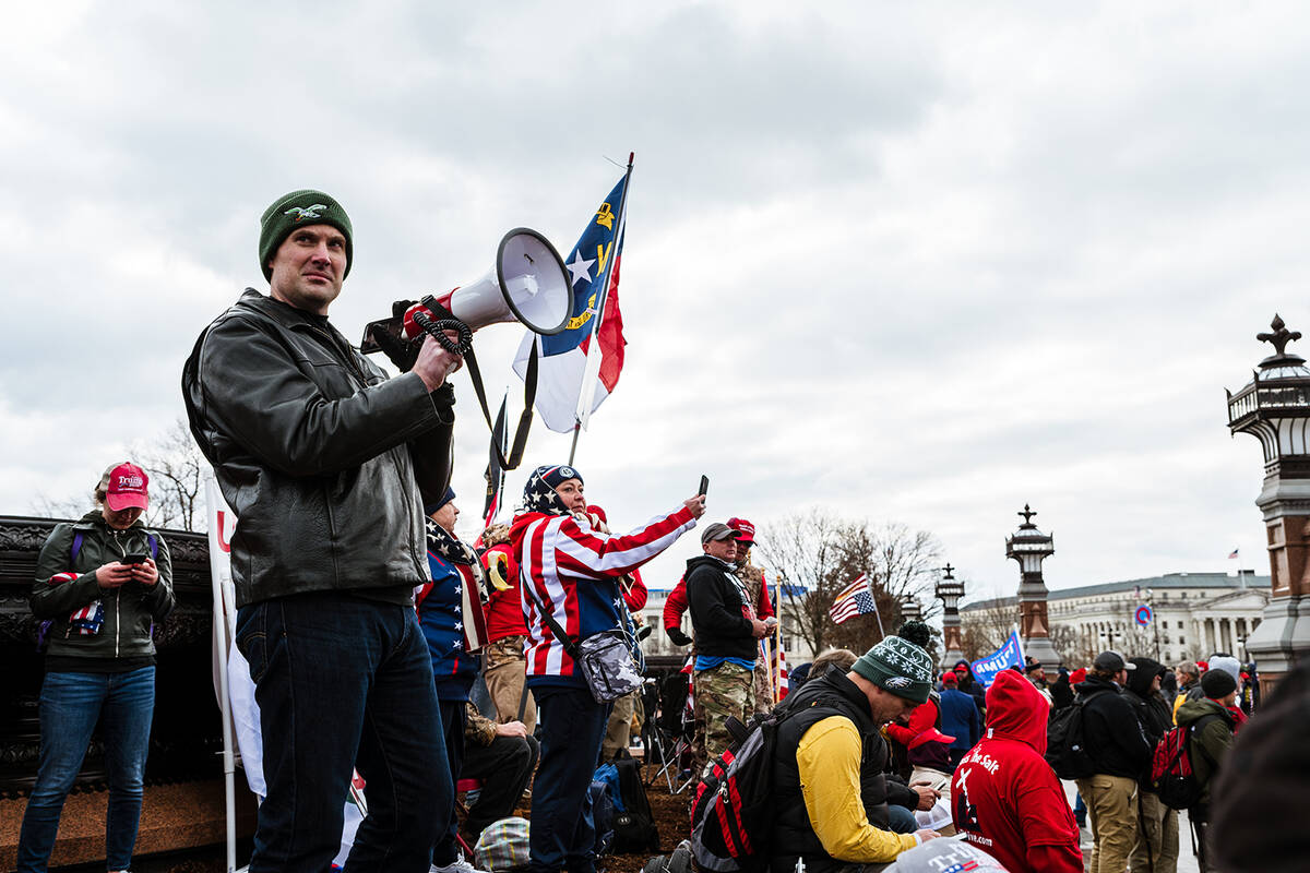 A pro-Trump protester leads a crowd in a chant with a megaphone in front of the U.S. Capitol Bu ...