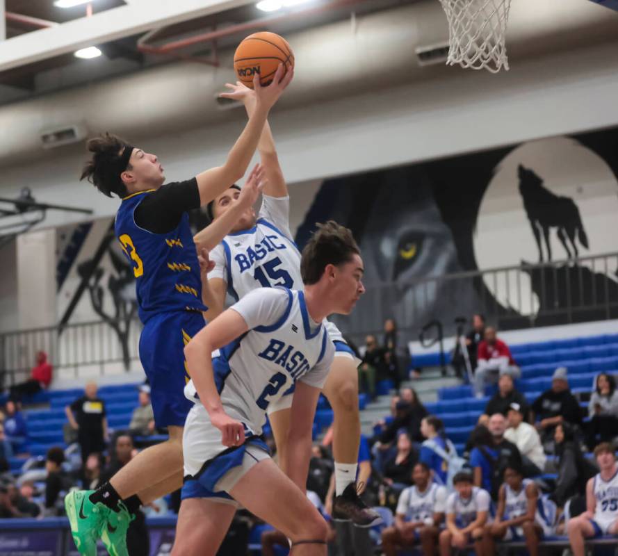 Sierra Vista guard Mark Beeten (13) lays up the ball against Basic guards Dax Salem (15) and gu ...