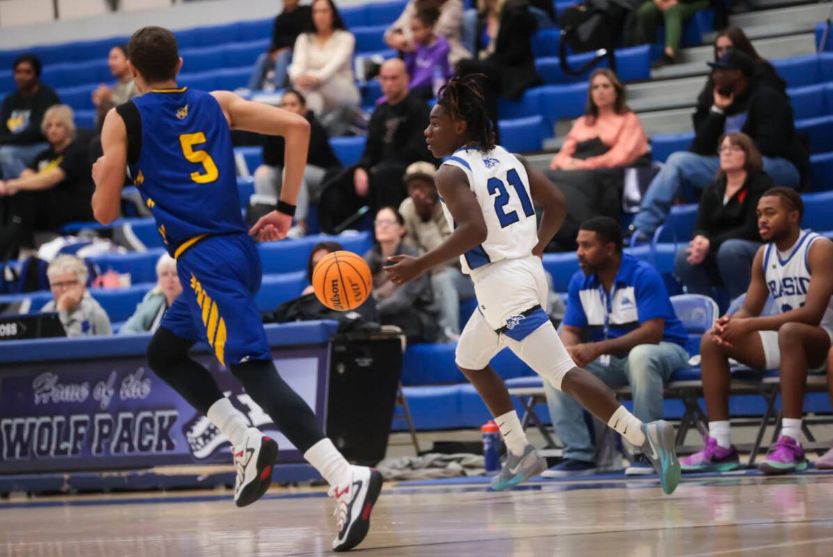 Basic guard Kenny Williams (21) brings the ball up court against Sierra Vista during a basketba ...