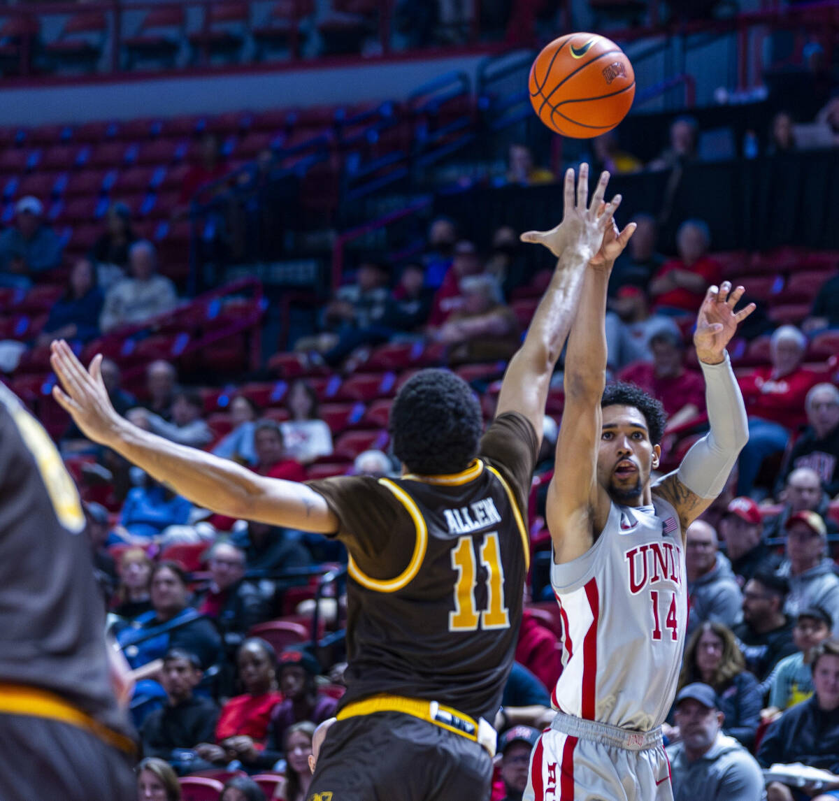 UNLV guard Jailen Bedford (14) post ups a three-point shot over Wyoming Cowboys guard Dontaie A ...