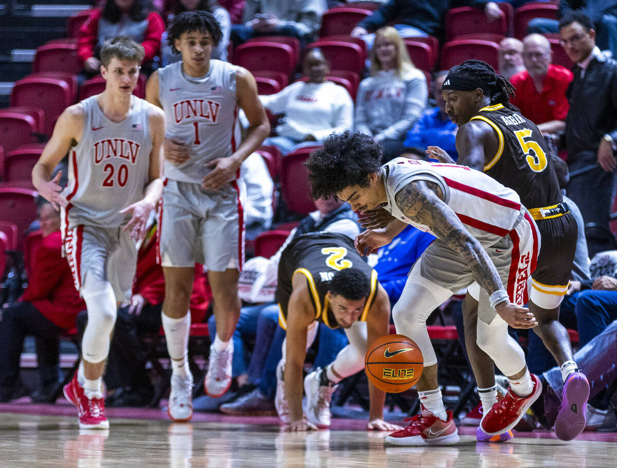 UNLV guard Brooklyn Hicks (13) looks to scoop up a loose ball lost by Wyoming Cowboys guard Kob ...