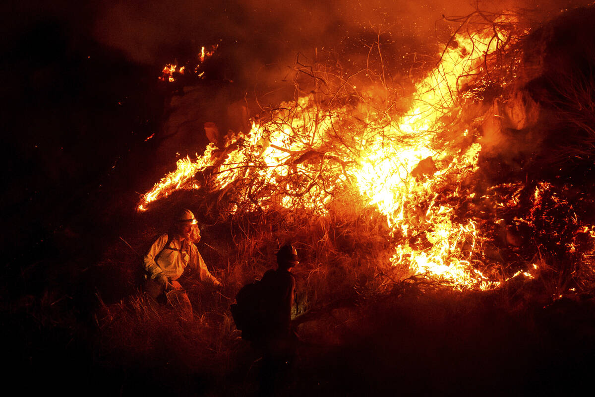 Firefighters battle the Lilac Fire along Interstate 15 near the Bonsall community of San Diego ...