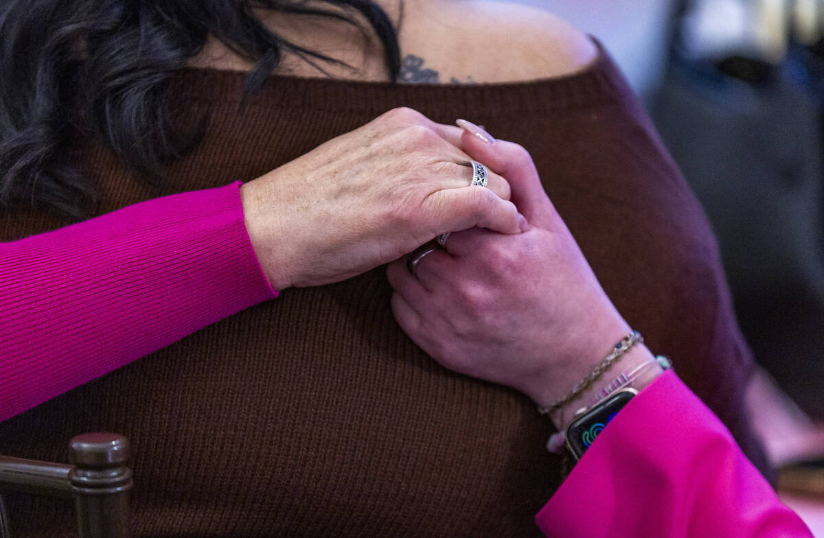 Family members hold hands during a remembrance gathering for Renise “NeNe” Wolfe ...