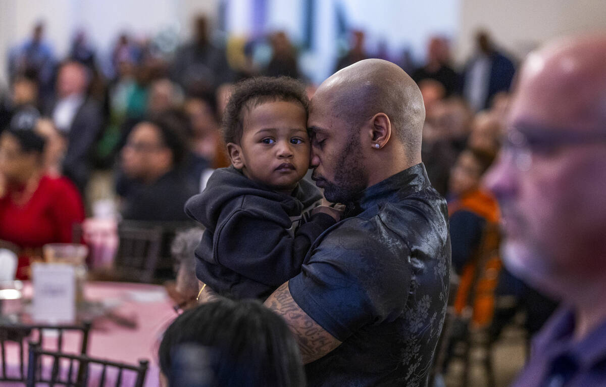 Michigan cousin Nick Piggee embraces his son Dominick, 1, after traveling with family to attend ...