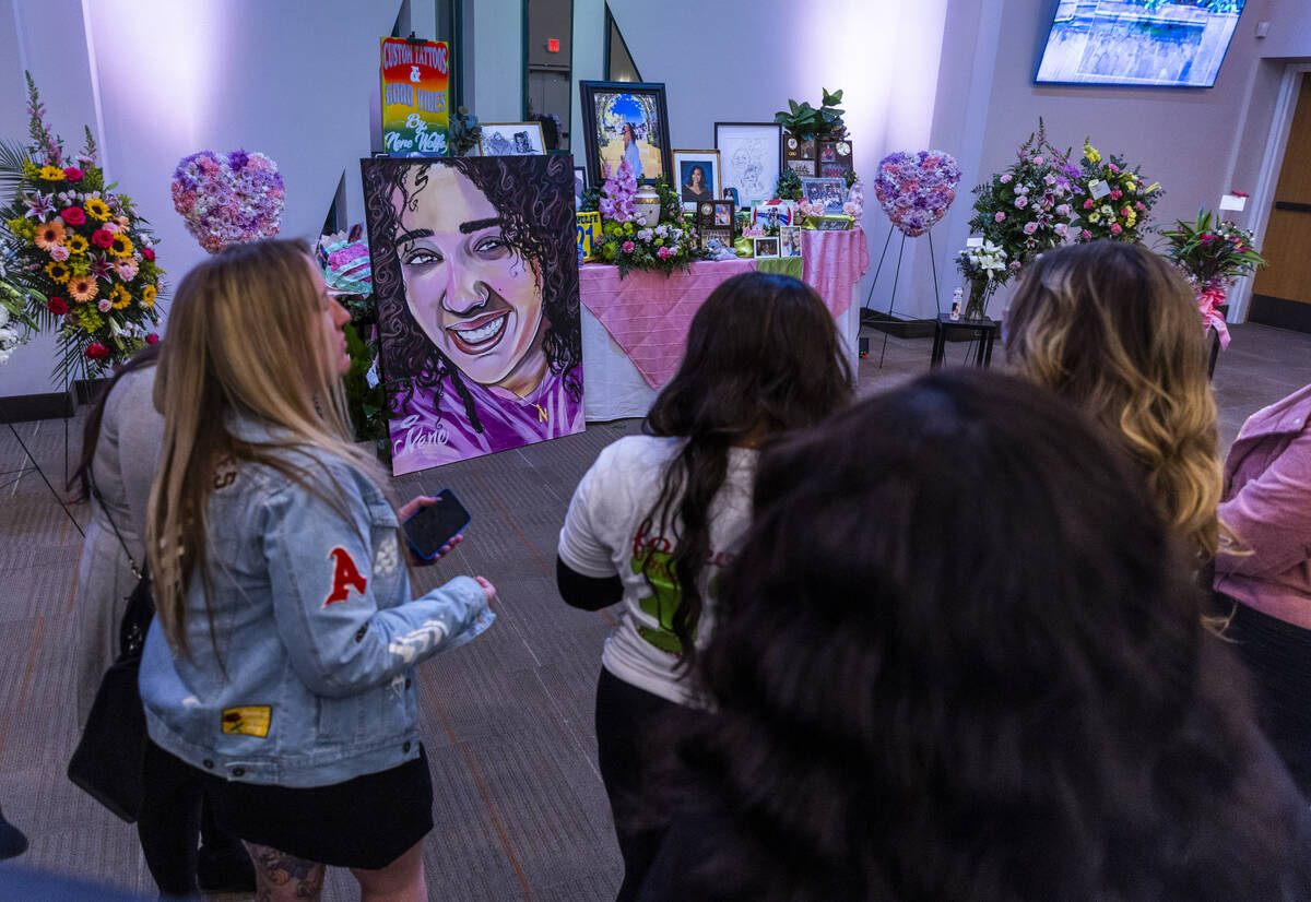 Friends gather amongst a table of mementos and a new painting by artist Big Fox during a rememb ...