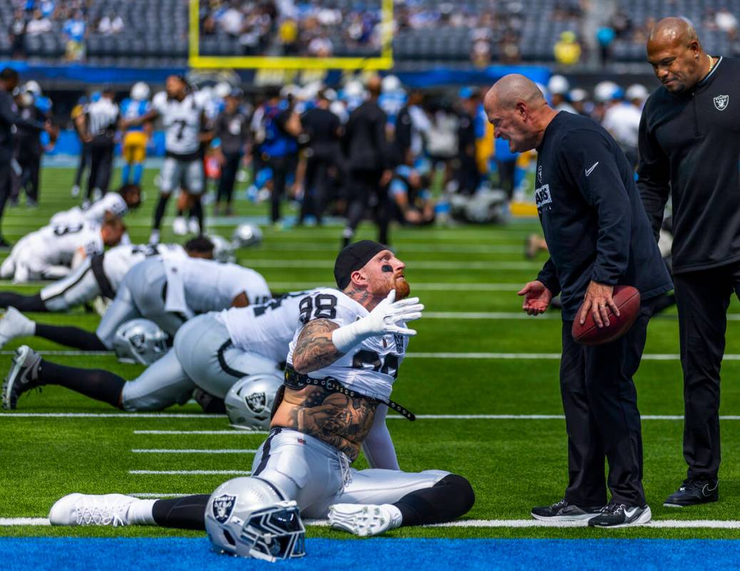 Raiders defensive end Maxx Crosby (98) talks with special teams coordinator Tom McMahon and hea ...