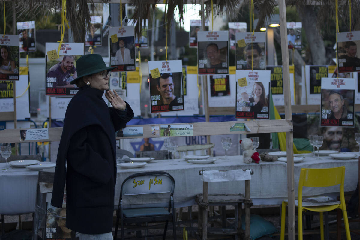A woman looks at a display of empty chairs representing hostages held by the Hamas militant gro ...