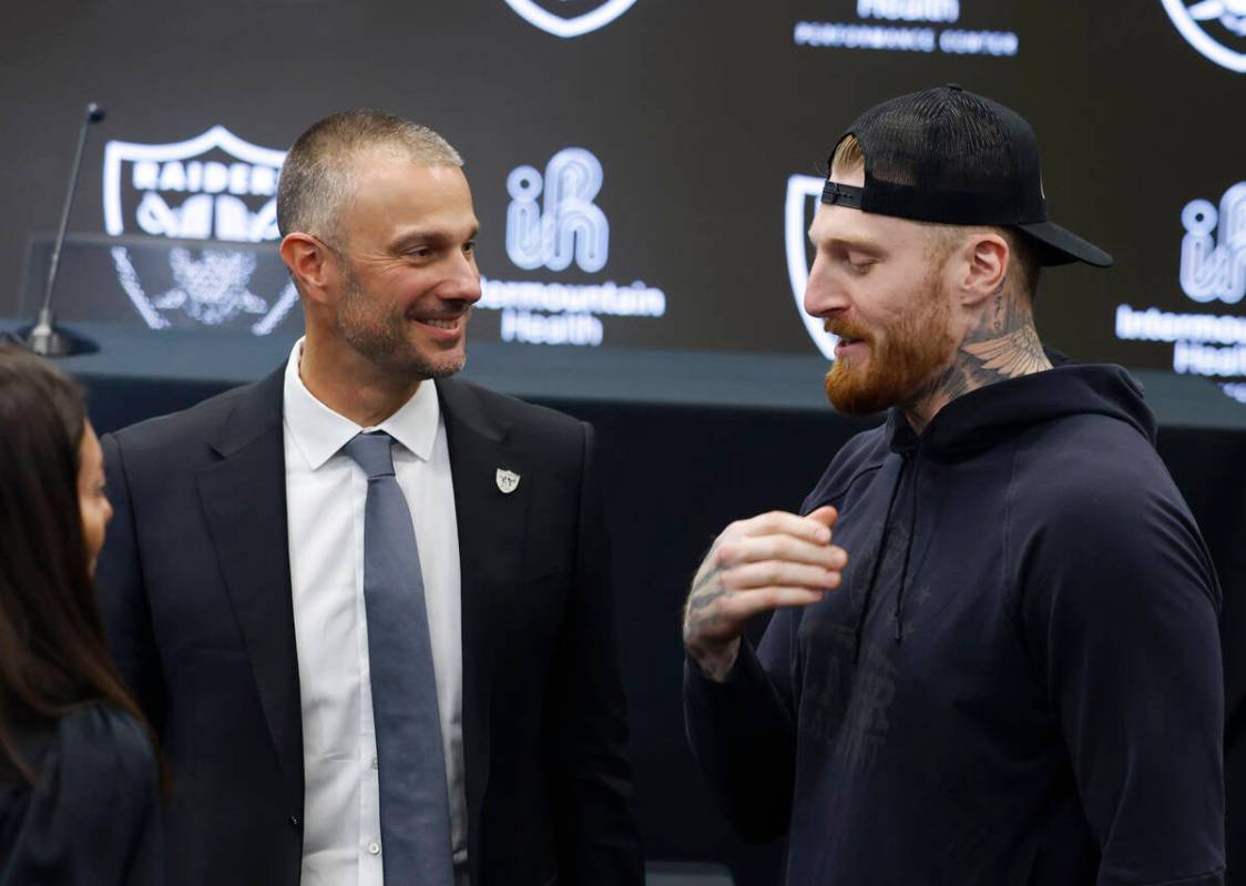 The new Raiders general manager John Spytek, left, chats with defensive end Max Crosby after a ...