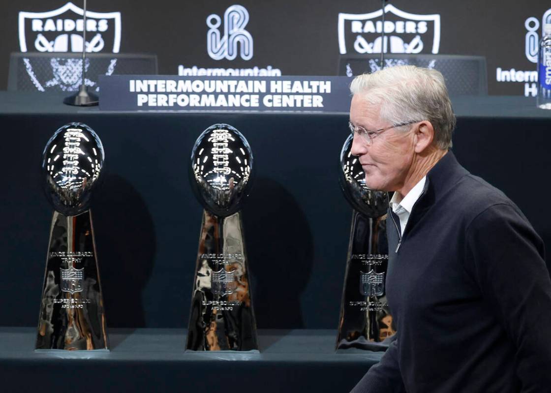 The new Raiders head coach Pete Carroll walks past three Lombardi trophies after a press confer ...