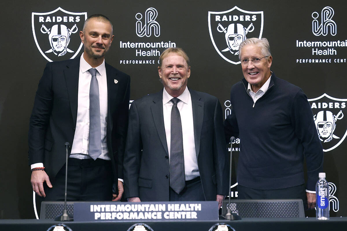 Raiders owner Mark Davis, center, poses for a photo after introducing their new general manager ...