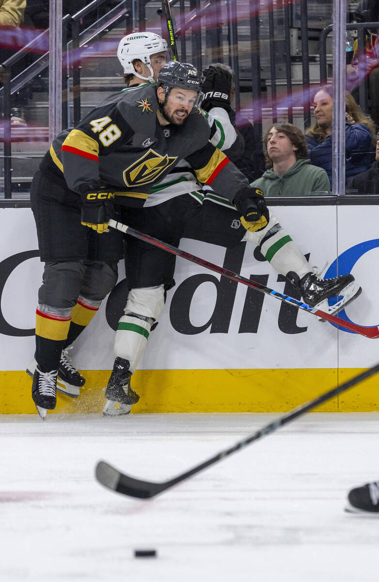 Golden Knights center Tomas Hertl (48) checks Dallas Stars center Wyatt Johnston (53) into the ...