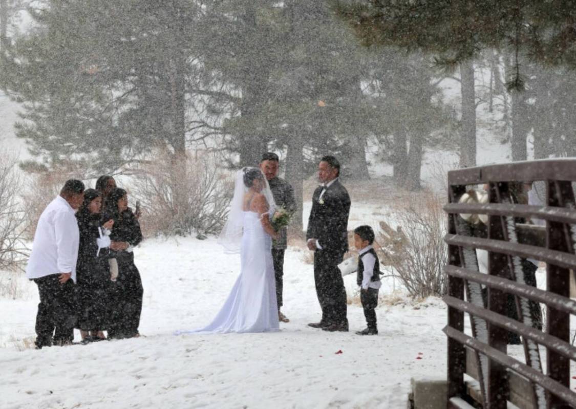 Delia and Evan Balderama of Ewa Beach, Hawaii, exchange wedding vows under a light snow in Uppe ...