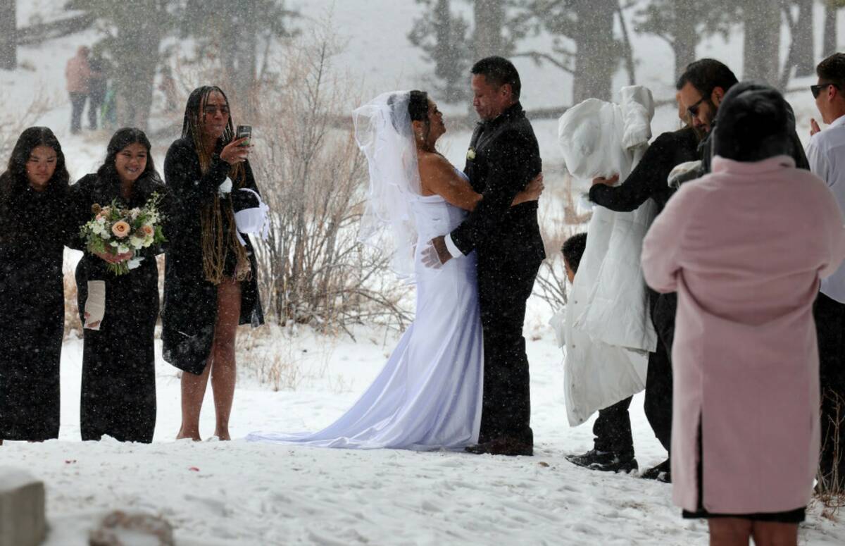 Delia and Evan Balderama of Ewa Beach, Hawaii, exchange wedding vows under a light snow in Uppe ...