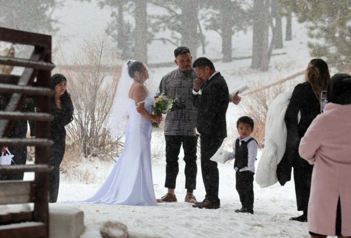 Delia and Evan Balderama of Ewa Beach, Hawaii, exchange wedding vows under a light snow in Uppe ...