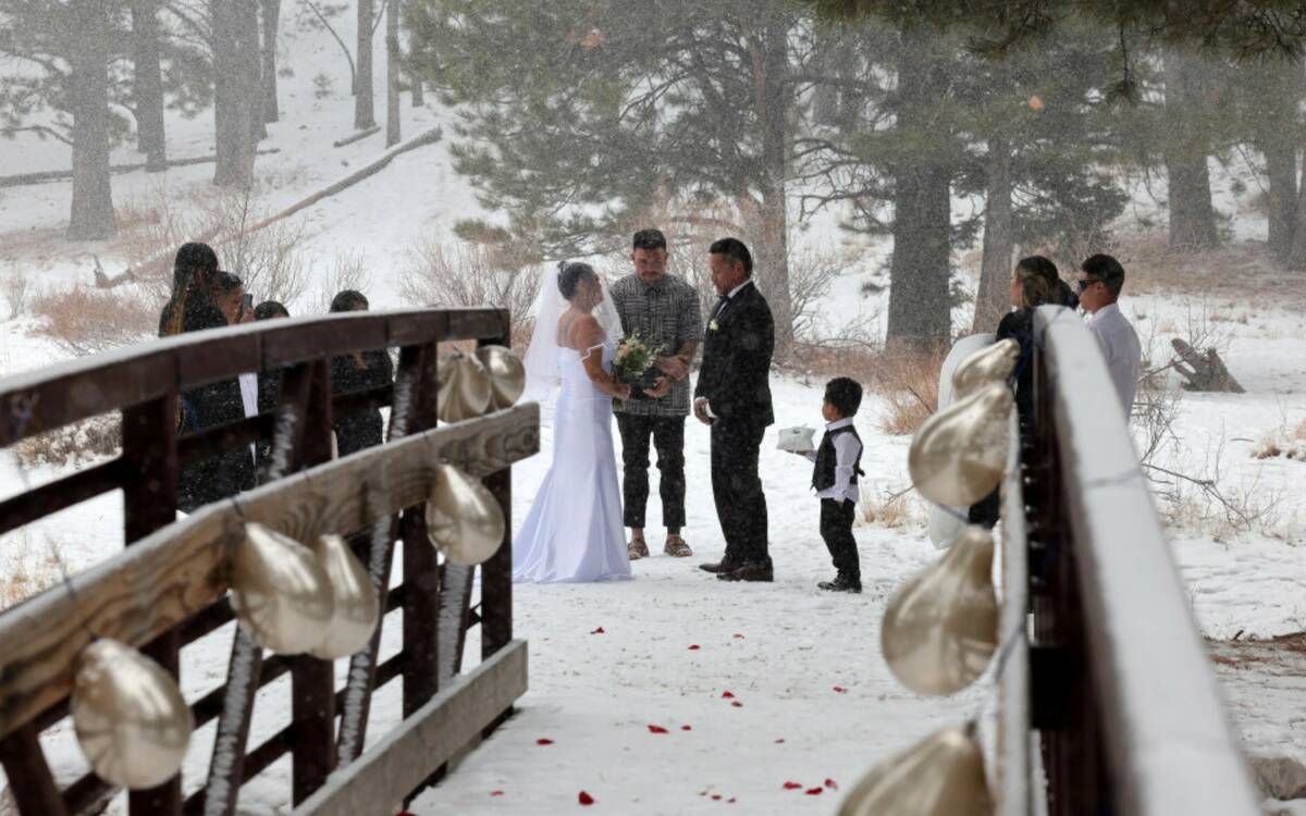 Delia and Evan Balderama of Ewa Beach, Hawaii, exchange wedding vows under a light snow in Uppe ...