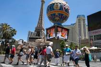 Tourists cross Las Vegas Boulevard near Paris hotel-casino on Friday, July 3, 2020, in Las Veg ...