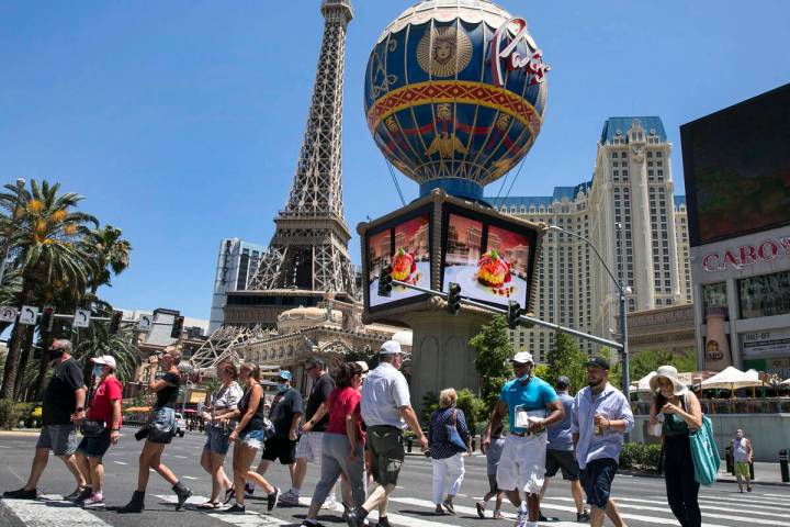 Tourists cross Las Vegas Boulevard near Paris hotel-casino on Friday, July 3, 2020, in Las Veg ...